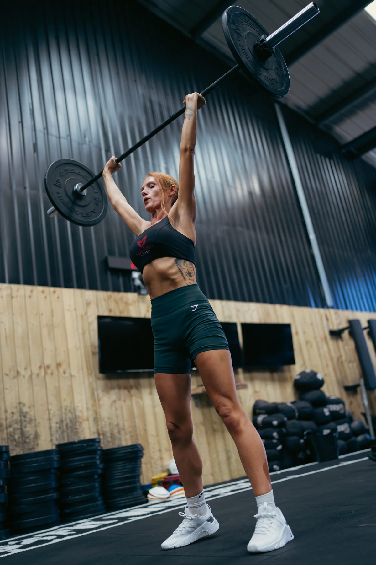 An athlete pressing a loaded barbell overhead